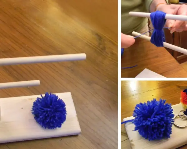 Creazione di pon pon di lana fai da te con un attrezzo in legno. Un pompon blu è pronto, un altro è in lavorazione.