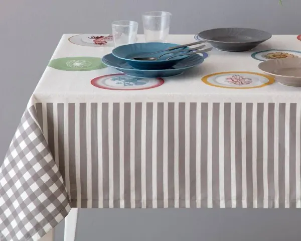Tovaglia a righe e quadretti con piatti colorati. Un'idea per sapere come smacchiare le tovaglie e mantenerle sempre perfette.