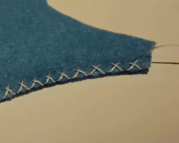 Bordo di feltro blu rifinito con un punto overlock a mano.