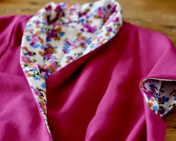 Dettaglio di un vestito estivo semplice fucsia con colletto e polsini foderati di tessuto floreale. Perfetto per imparare come cucire un vestito estivo semplice.