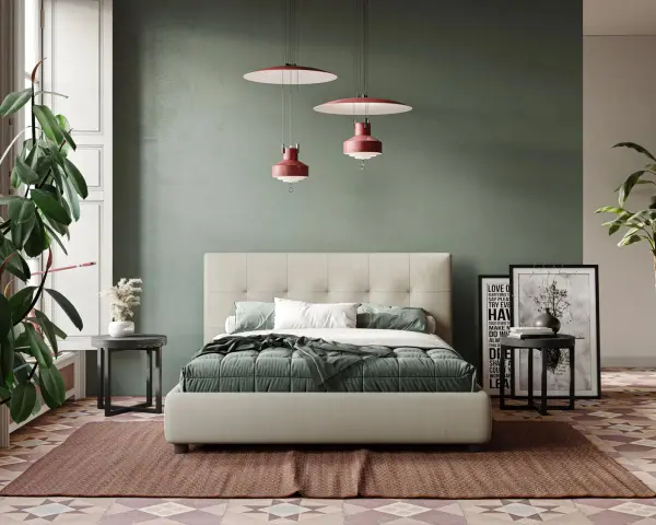 Letto moderno con testiera capitonné, copriletto verde e cuscini bianchi. Parti del letto ben visibili, con comodini e piante.