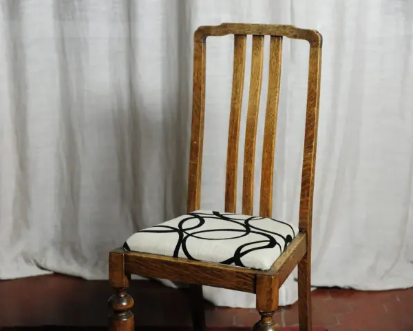 Sedia in legno con seduta imbottita e fantasia geometrica. Un esempio di come tappezzare sedie per rinnovare l'arredo.