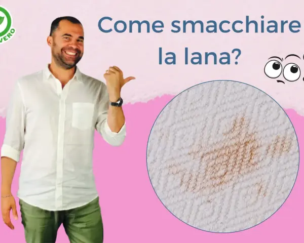 Uomo sorridente indica una macchia su tessuto di lana. Impara come smacchiare la lana con consigli pratici.