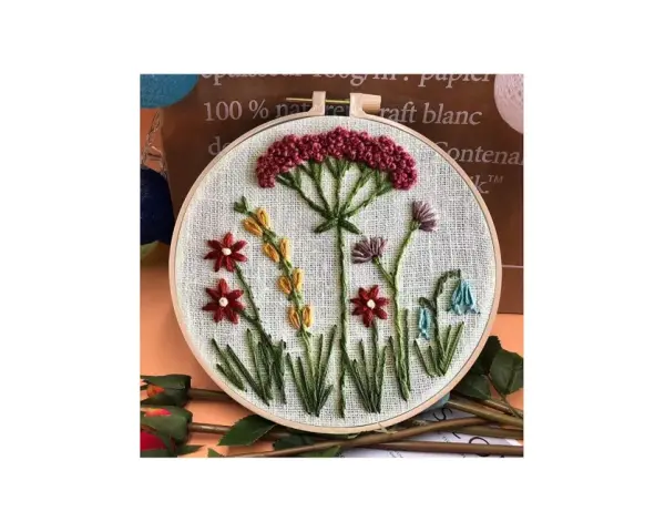 Embroidery hoop with a simple floral design featuring red, yellow, purple, and blue flowers.
