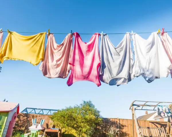 Panni colorati stesi al sole su un filo, un'immagine di vita quotidiana e la gioia di stendere i panni all'aria aperta.