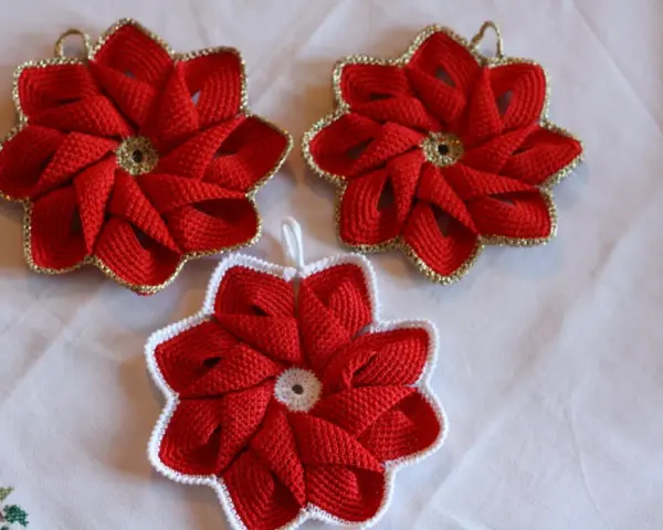 Tre presine natalizie fai da te a forma di stella rossa, con bordi dorati o bianchi, perfette per decorare la tavola.