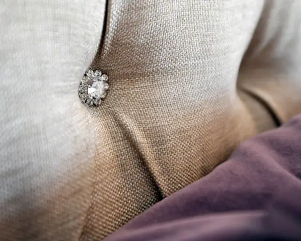 Tessuto per rivestimenti con un bottone decorativo tempestato di strass.