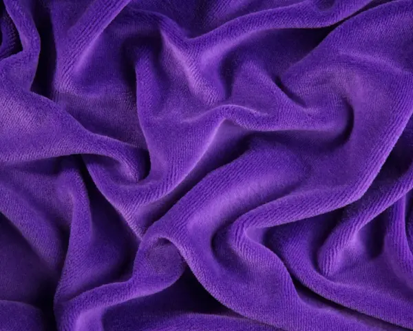 Tessuto di velluto viola drappeggiato, morbido e soffice. Scopri come lavare il velluto per mantenerlo splendente.