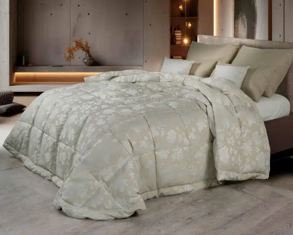Un piumone matrimoniale con un delicato motivo floreale color crema, morbido e accogliente. Chissà quanto pesa un piumone matrimoniale così bello?