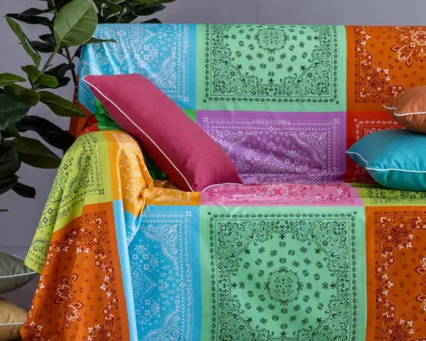 Un modo creativo per coprire una poltrona con un foulard colorato, creando un patchwork vivace.