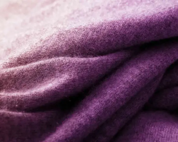 Tessuto di lana viola sfumato, ideale per imparare come tingere un maglione di lana e ottenere questo colore vibrante.