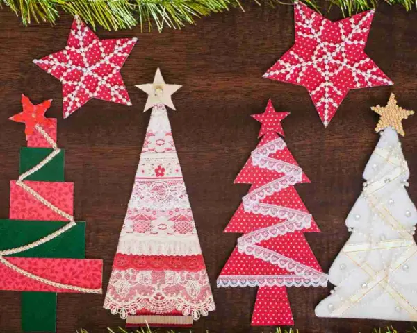 Alberi di Natale fai da te in stoffa, decorati con pizzi e stelle, creano un'atmosfera festiva e artigianale.