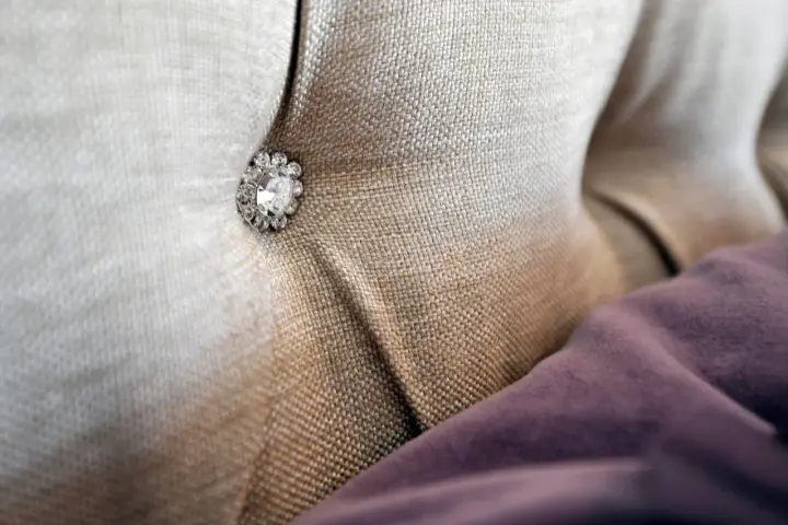 Tessuto per rivestimenti con un bottone decorativo tempestato di strass.