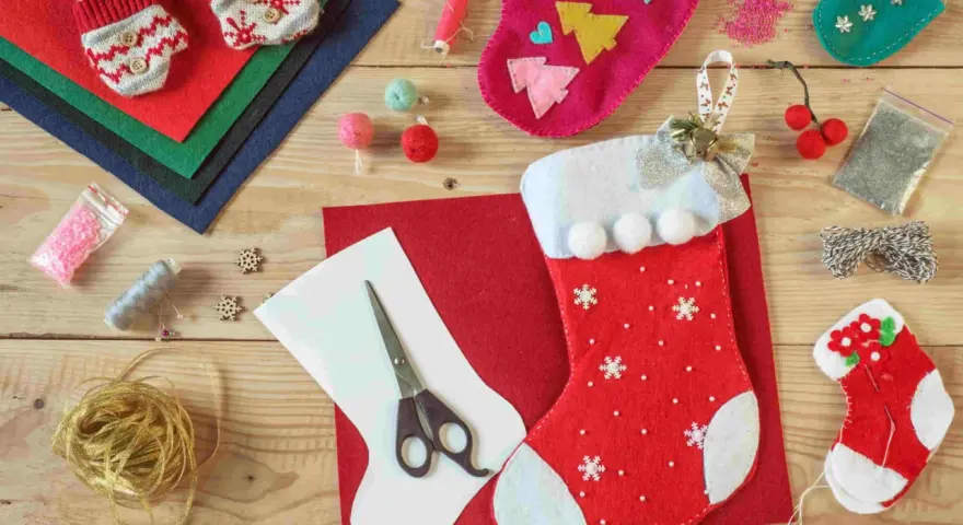 Materiali per calze Befana personalizzate fai da te: pannolenci, forbici, filo, perline e decorazioni per creare la tua calza unica.
