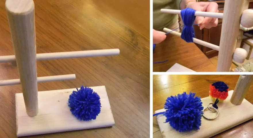 Creazione di pon pon di lana fai da te con un attrezzo in legno. Un pompon blu è pronto, un altro è in lavorazione.