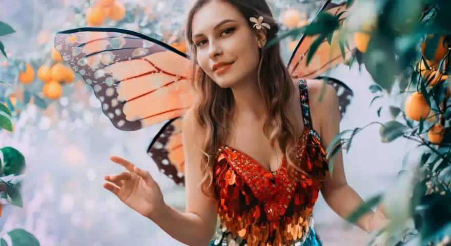 Ragazza con ali da farfalla e abito scintillante, un'idea per vestiti carnevale donna fai da te.