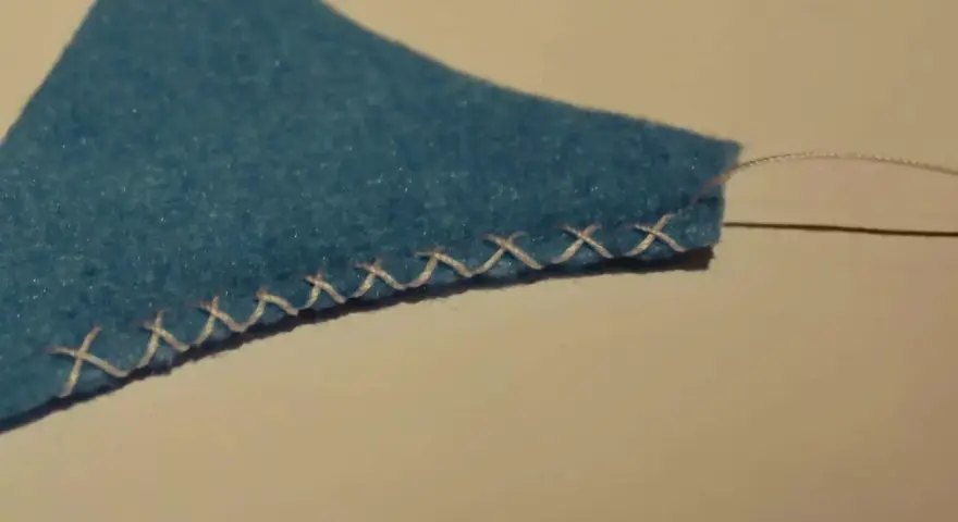 Bordo di feltro blu rifinito con un punto overlock a mano.