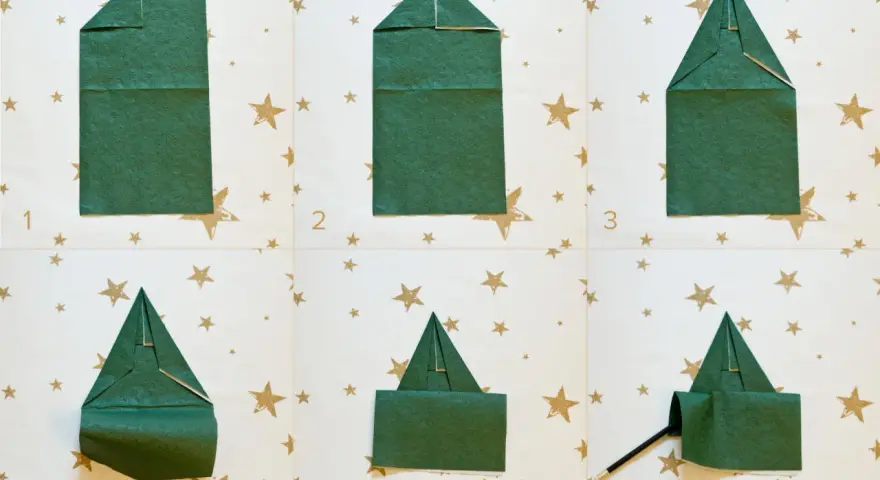 Passaggi per creare alberelli di Natale con tovaglioli piegati. Un modo creativo per decorare la tavola delle feste.