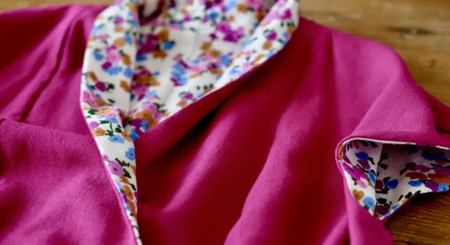 Dettaglio di un vestito estivo semplice fucsia con colletto e polsini foderati di tessuto floreale. Perfetto per imparare come cucire un vestito estivo semplice.