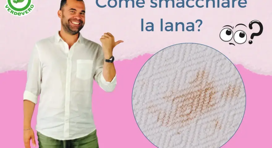 Uomo sorridente indica una macchia su tessuto di lana. Impara come smacchiare la lana con consigli pratici.
