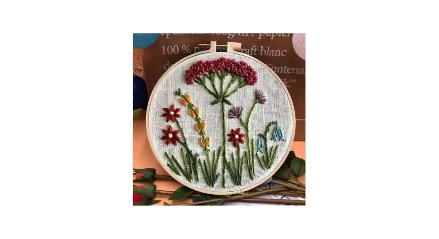Embroidery hoop with a simple floral design featuring red, yellow, purple, and blue flowers.