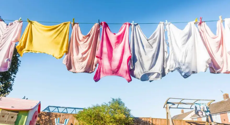 Panni colorati stesi al sole su un filo, un'immagine di vita quotidiana e la gioia di stendere i panni all'aria aperta.