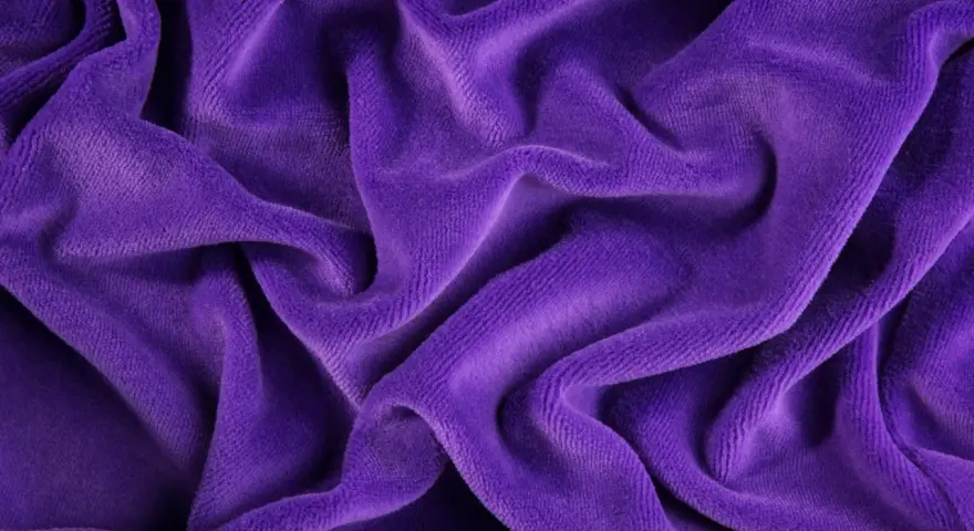 Tessuto di velluto viola drappeggiato, morbido e soffice. Scopri come lavare il velluto per mantenerlo splendente.