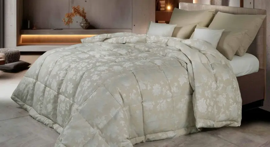 Un piumone matrimoniale con un delicato motivo floreale color crema, morbido e accogliente. Chissà quanto pesa un piumone matrimoniale così bello?