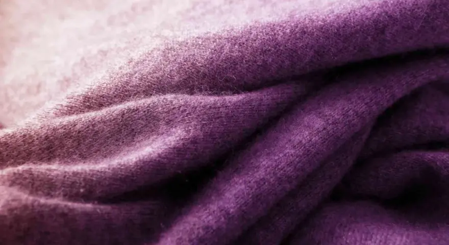 Tessuto di lana viola sfumato, ideale per imparare come tingere un maglione di lana e ottenere questo colore vibrante.