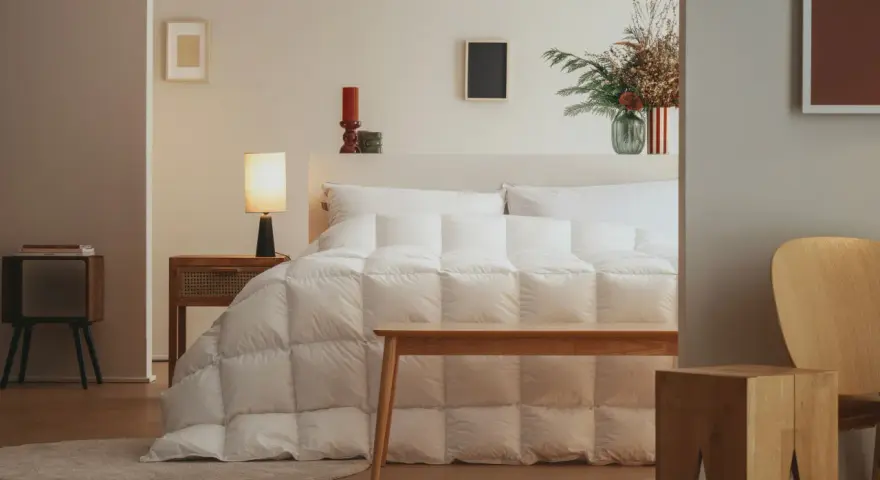 Un letto accogliente con un piumone bianco trapuntato, pronto per accogliere la parte tonda del piumone dove va, creando un nido perfetto.