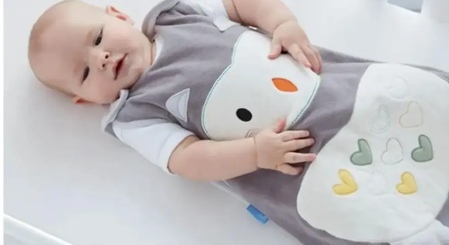 Bambino in sacco nanna con simpatico disegno di gufo. Il sacco nanna è ideale per neonati e bambini piccoli, offrendo comfort e sicurezza durante il sonno.