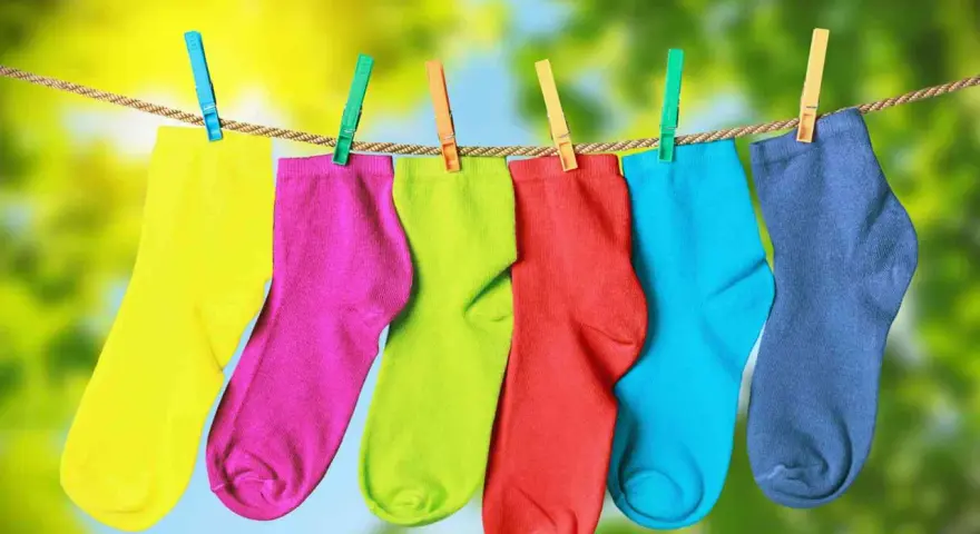 Calzini colorati appesi ad asciugare, un modo semplice per capire come fissare il colore sui tessuti.