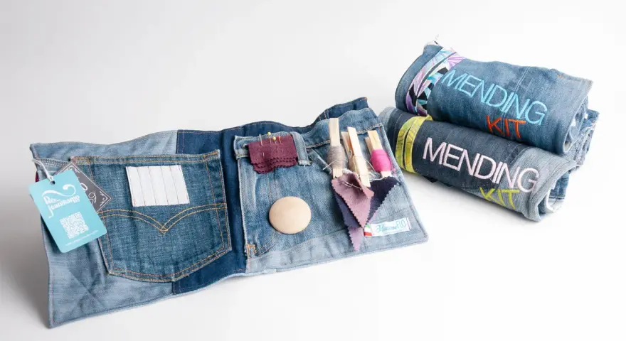 Kit per rammendo creativo jeans: tasche con fili, aghi, tessuti e bottoni. Arrotolati, altri kit con scritta "Mending Kit".
