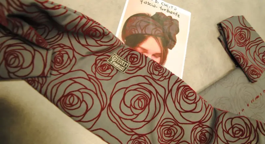 Tessuto grigio con rose rosse, ideale per imparare come fare un turbante di stoffa.