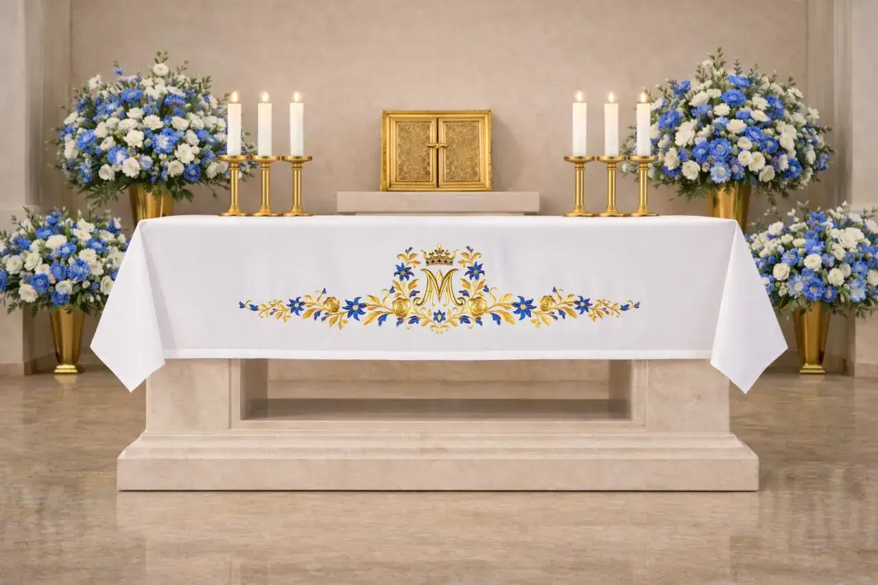 Altare con tovaglia bianca ricamata, fiori blu e bianchi, candele accese e tabernacolo dorato, perfetta per confezionare una tovaglia per altare.