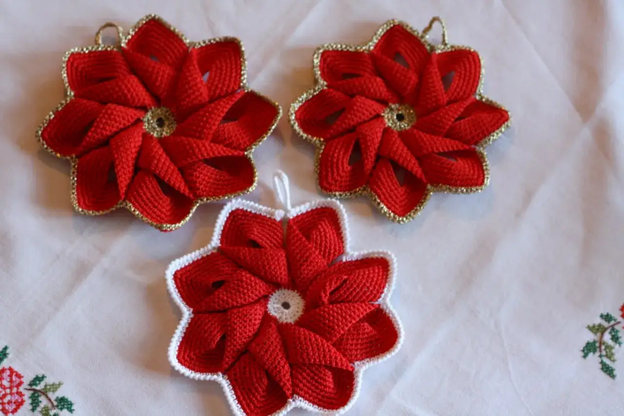 Tre presine natalizie fai da te a forma di stella rossa, con bordi dorati o bianchi, perfette per decorare la tavola.
