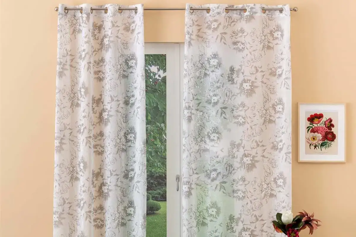 Tende con occhielli decorate con fiori, perfette per capire come mettere le tende con bastone sopra il cassonetto.