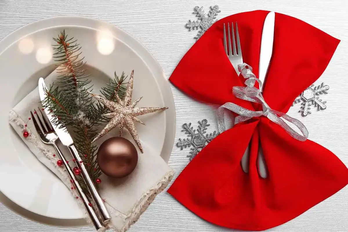 Tovaglioli piegati per Natale, con posate e decorazioni festive. Un'elegante mise en place per le feste.