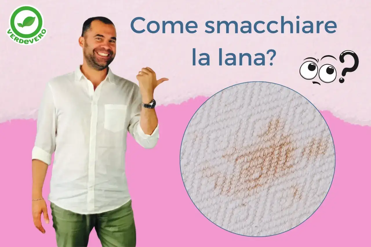 Uomo sorridente indica una macchia su tessuto di lana. Impara come smacchiare la lana con consigli pratici.