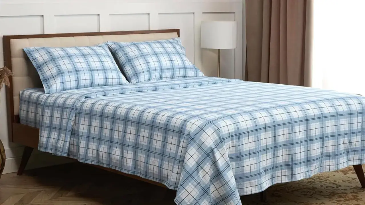Letto con lenzuola di flanella a quadri azzurri e bianchi. Nonostante la loro morbidezza, a volte le lenzuola di flanella fanno male, graffiando la pelle.