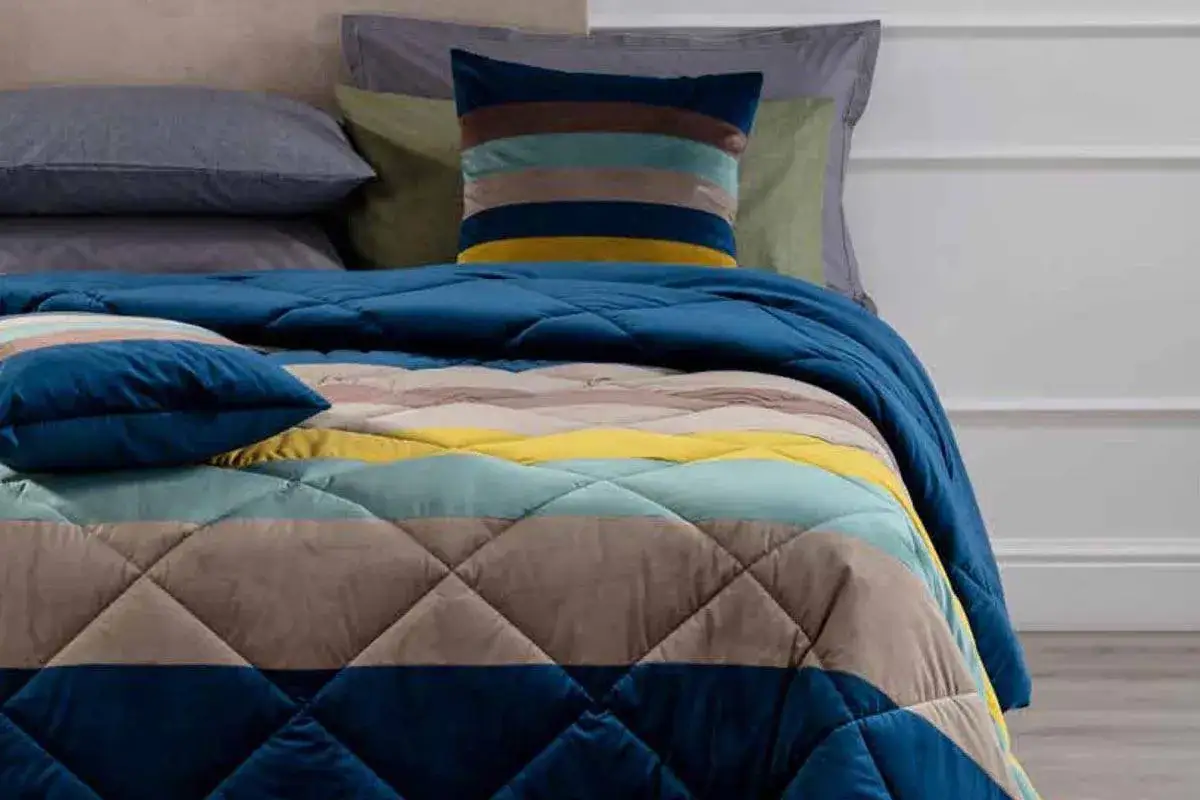 Letto con trapuntino a righe colorate, un'alternativa leggera al piumone per un comfort visivo e tattile.