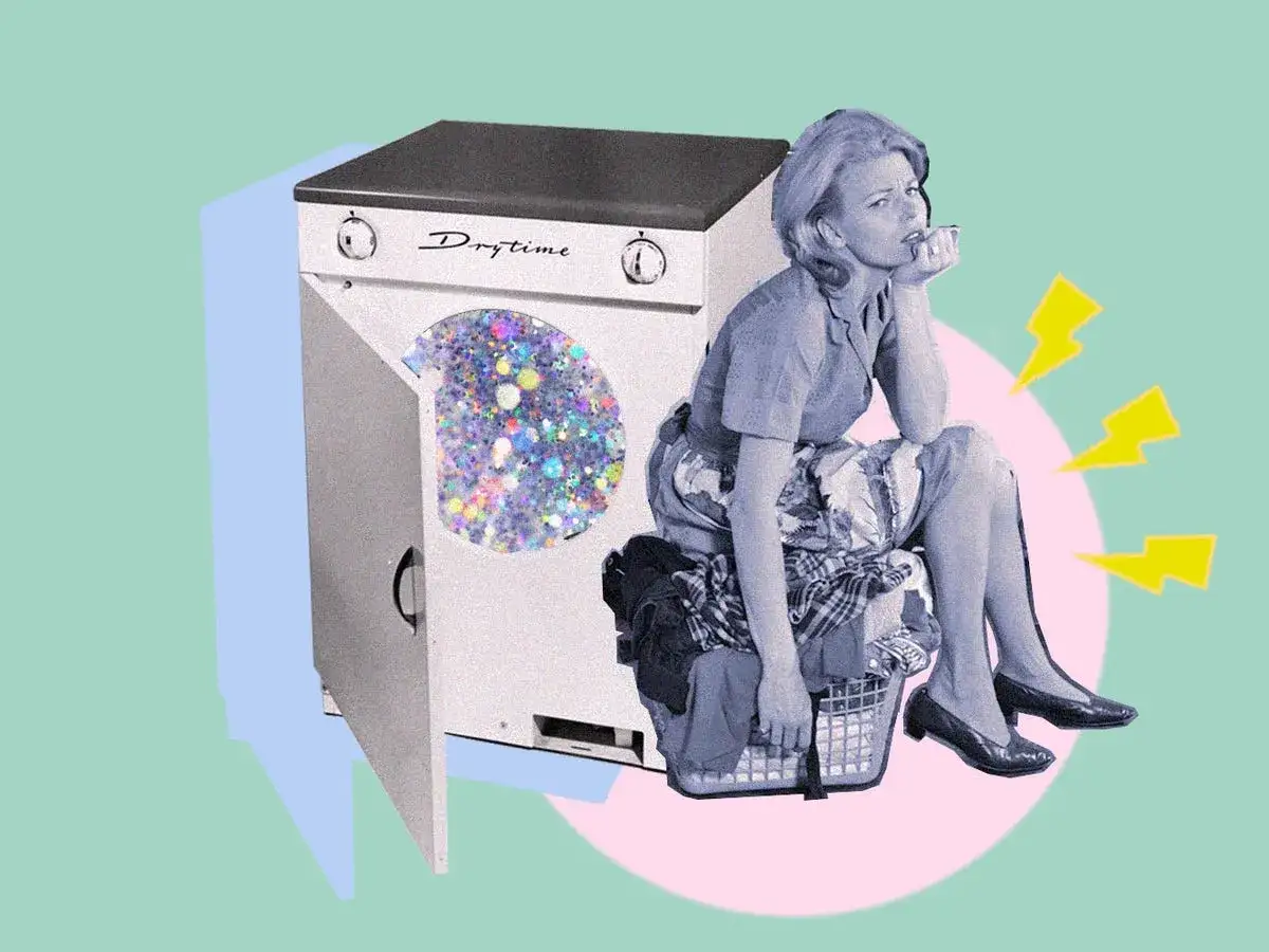 Donna annoiata seduta su un cesto di panni, accanto a una lavatrice con glitter. Scopri come disinfettare i vestiti senza lavarli.