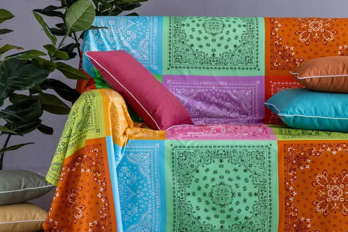 Un modo creativo per coprire una poltrona con un foulard colorato, creando un patchwork vivace.