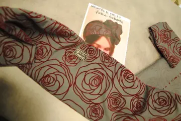 Tessuto grigio con rose rosse, ideale per imparare come fare un turbante di stoffa.